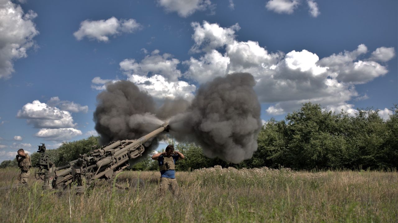 Soldiers cover their ears after the firing of an air cannon as Ukrainian artillery division supports soldiers in a counteroffensive on the Zaporizhzhya frontline with M777, on July 16, 2023. 