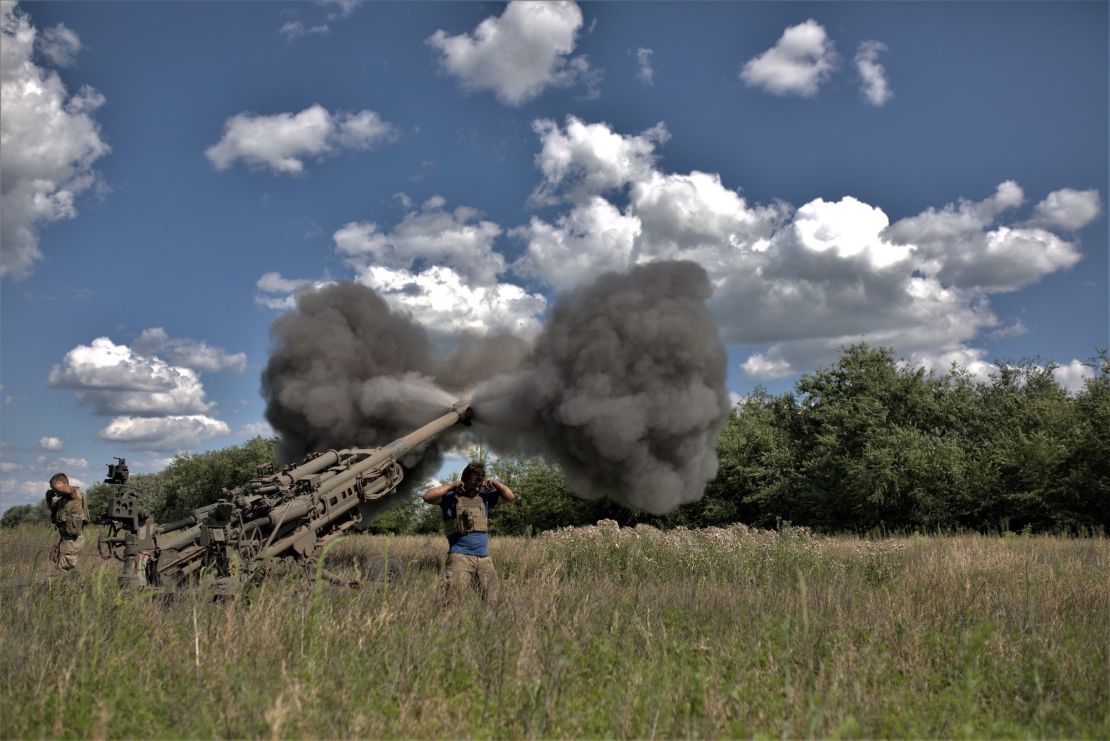 Soldiers cover their ears after the firing of an air cannon as Ukrainian artillery division supports soldiers in a counteroffensive on the Zaporizhzhya frontline with M777, on July 16, 2023. 