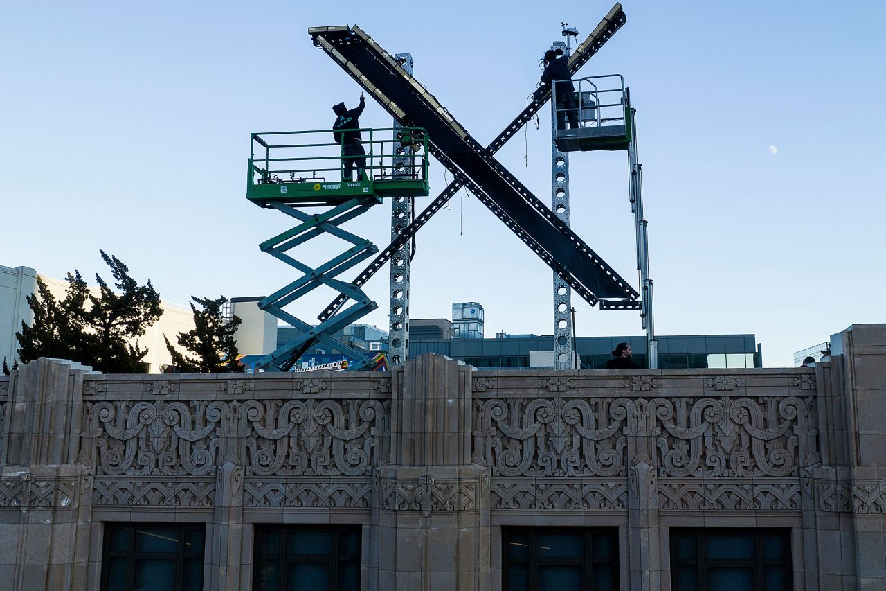 Workers install lighting on an "X" sign atop the San Francisco headquarters of the company formerly known as Twitter on Friday, July 28. The "X" was <a href="https://www.cnn.com/2023/07/31/tech/x-sign-twitter-elon-musk/index.html" target="_blank">dismantled days later</a>. 