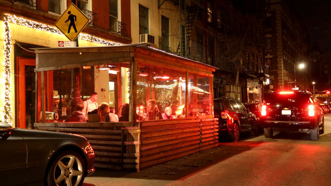 People eat dinner in an outdoor sidewalk shed at a restaurant on Bedford Street in Greenwich Village on December 17, 2021 in New York City.