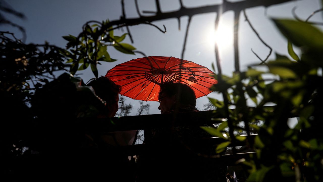 A woman uses an umbrella during an unusual winter period heatwave in Santiago, Chile, August 3, 2023. 
