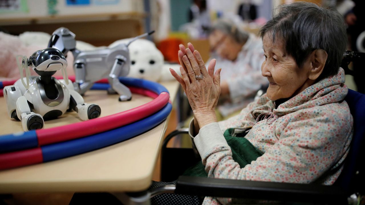 A resident claps to call 'AIBO', a pet dog robot at Shin-tomi nursing home in Tokyo, Japan, February 2, 2018. REUTERS/Kim Kyung-Hoon  SEARCH "KYUNG-HOON ROBOTS" FOR THIS STORY. SEARCH "WIDER IMAGE" FOR ALL STORIES.