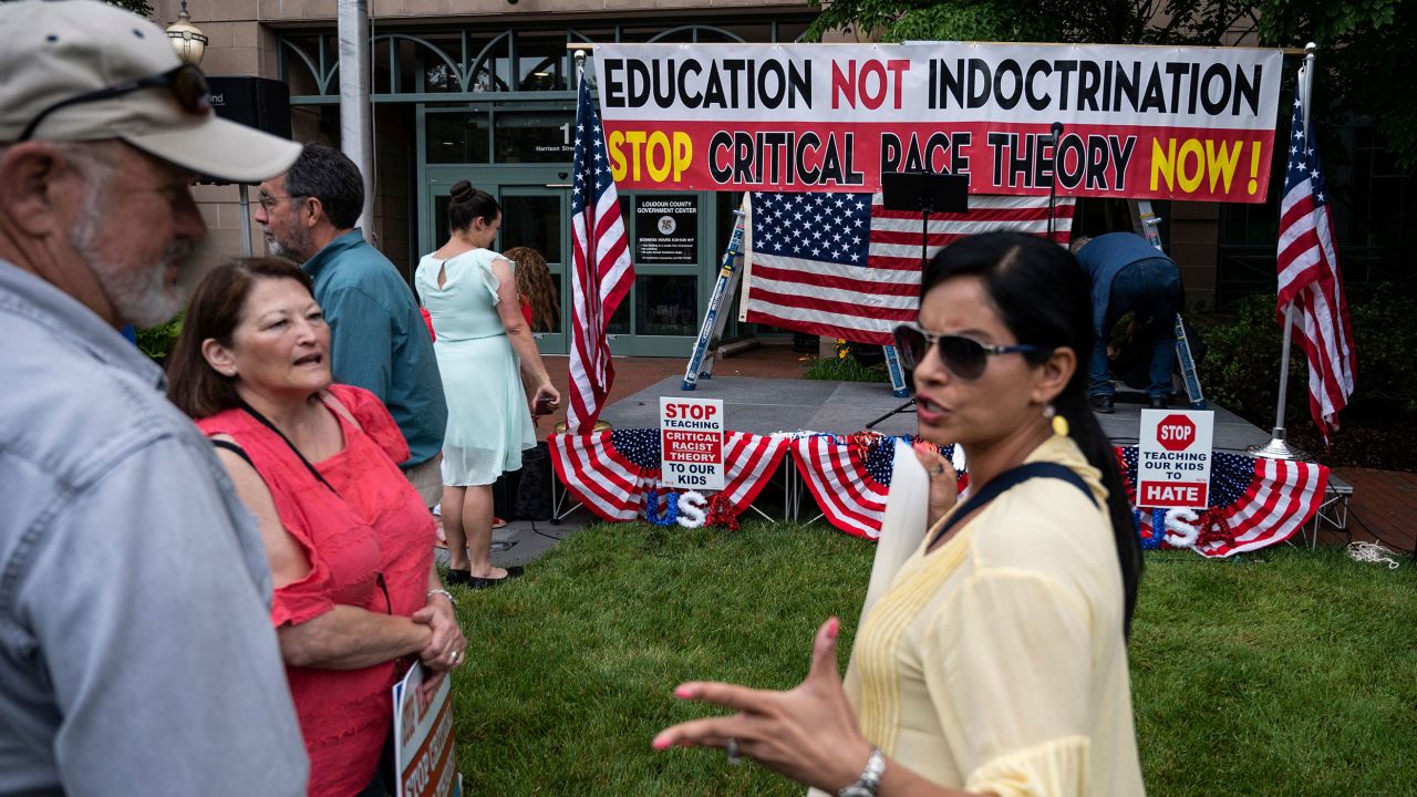 People talk before the start of a rally against "critical race theory" (CRT) being taught in schools at the Loudoun County Government center in Leesburg, Virginia on June 12, 2021. - "Are you ready to take back our schools?" Republican activist Patti Menders shouted at a rally opposing anti-racism teaching that critics like her say trains white children to see themselves as "oppressors." "Yes!", answered in unison the hundreds of demonstrators gathered this weekend near Washington to fight against "critical race theory," the latest battleground of America's ongoing culture wars. The term "critical race theory" defines a strand of thought that appeared in American law schools in the late 1970s and which looks at racism as a system, enabled by laws and institutions, rather than at the level of individual prejudices. But critics use it as a catch-all phrase that attacks teachers' efforts to confront dark episodes in American history, including slavery and segregation, as well as to tackle racist stereotypes. (Photo by ANDREW CABALLERO-REYNOLDS / AFP) (Photo by ANDREW CABALLERO-REYNOLDS/AFP via Getty Images)