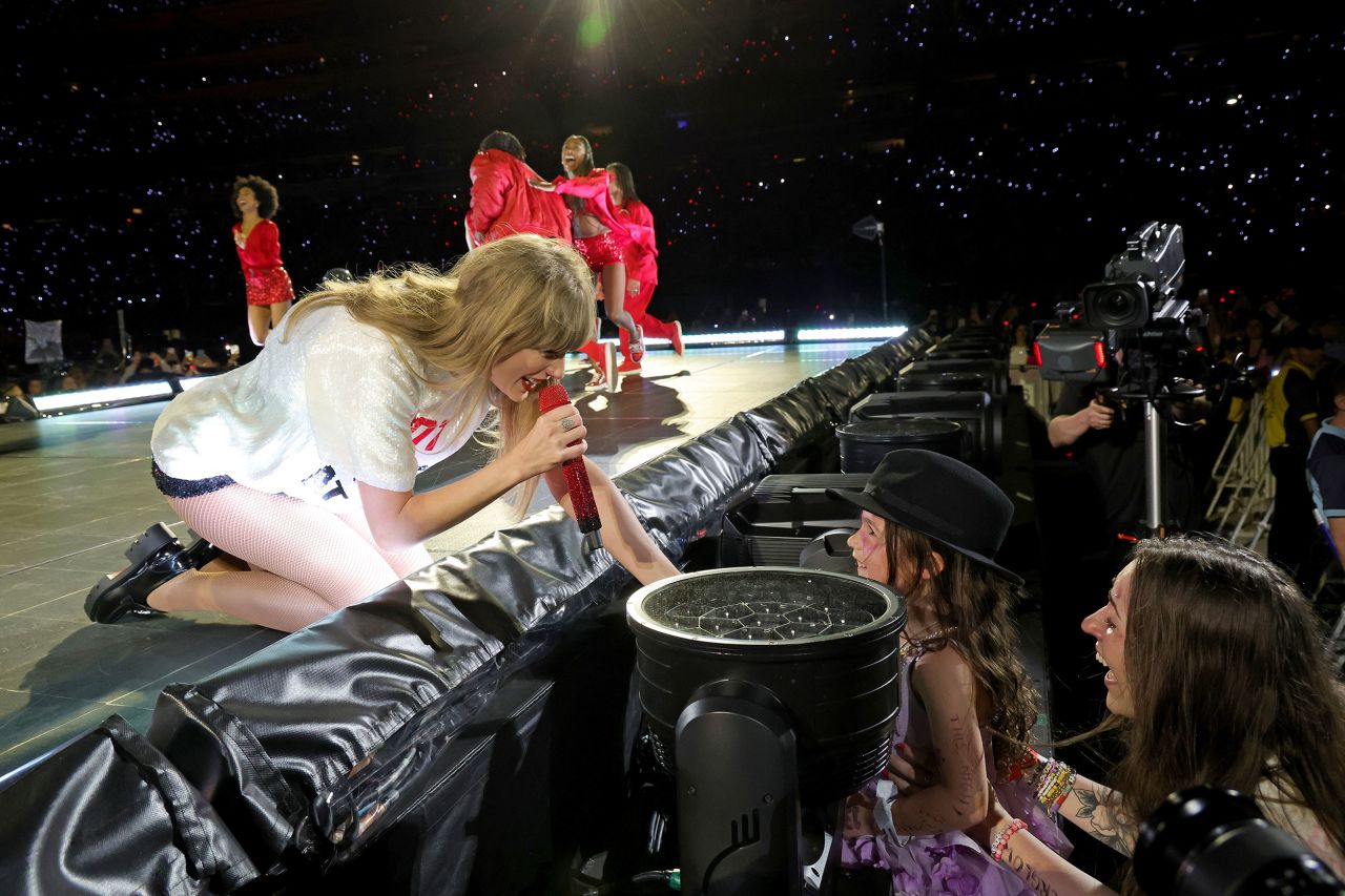 Swift gives her hat to a young fan in East Rutherford on May 27. Each night of the tour, Swift selects one lucky fan to receive a signed hat at the end of her song "22."