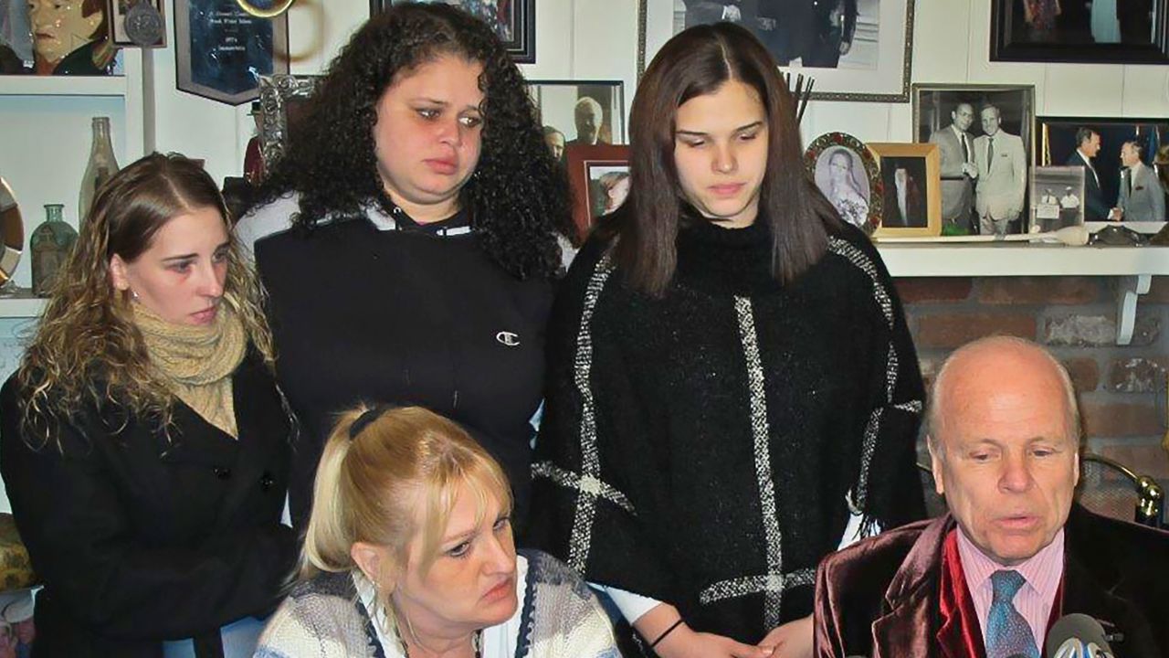 Sarra Gilbert, center, stands between her sisters Stevie Smith, left, and Sherre Gilbert, right, at a 2016 news conference with her mother, Mari, and attorney John Ray.
