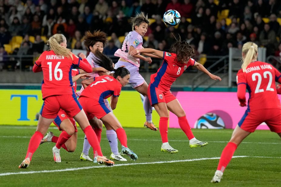 Japan's Mina Tanaka, center up, and Norway's Vilde Boe Risa challenge for the ball during the match.