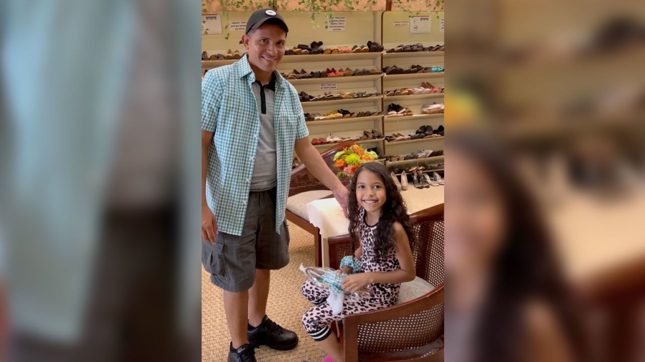 A dad wears a shirt made from the same fabric as his daughter's Barbie's dress.