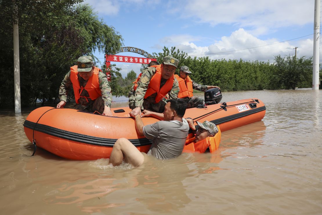 Rescuers pull a villager out of the water in Harbin on August 5.