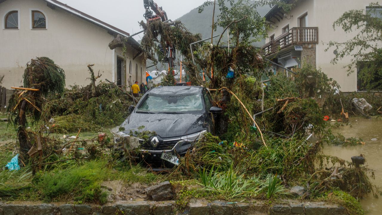 Унищожена кола в двора на къща, която беше наводнена от река Савиня в Назарие, Словения.