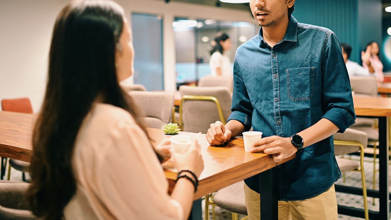 A young man and woman discussing start-up business ideas in a co-working office