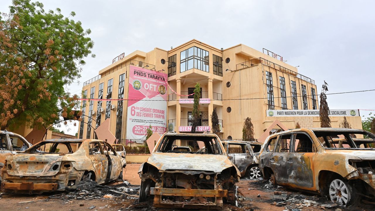Burned cars are seen on Monday outside the headquarters of the ousted President's political party.