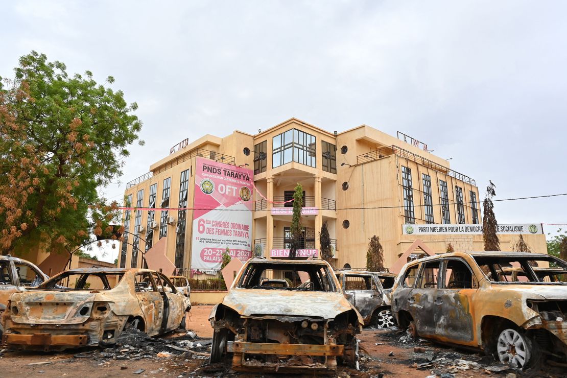 Burned cars are seen on Monday outside the headquarters of the ousted President's political party.