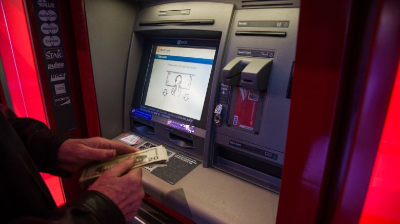 A customer withdraws money from an automatic teller machines (ATM) inside a Bank of America Corp. branch in New York, U.S., on Saturday, Jan. 13, 2018.