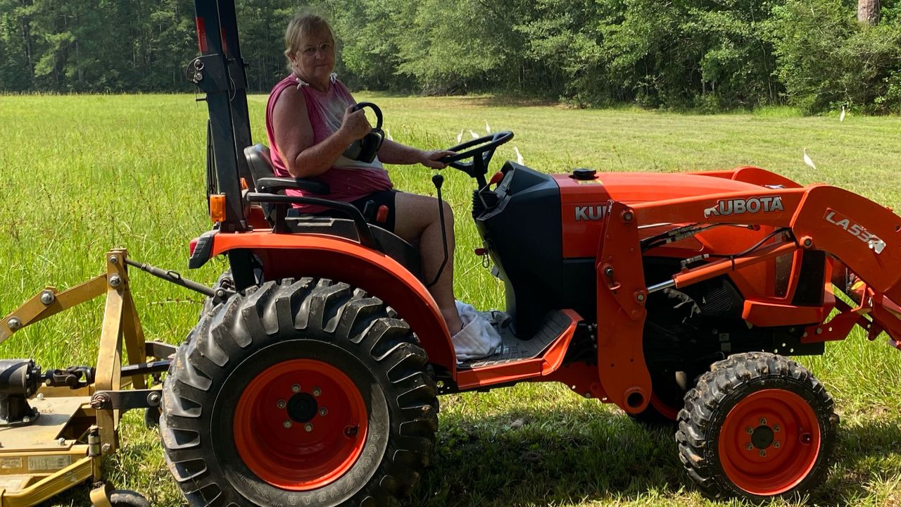 Peggy Jones sits on one of two tractors used to groom her property.