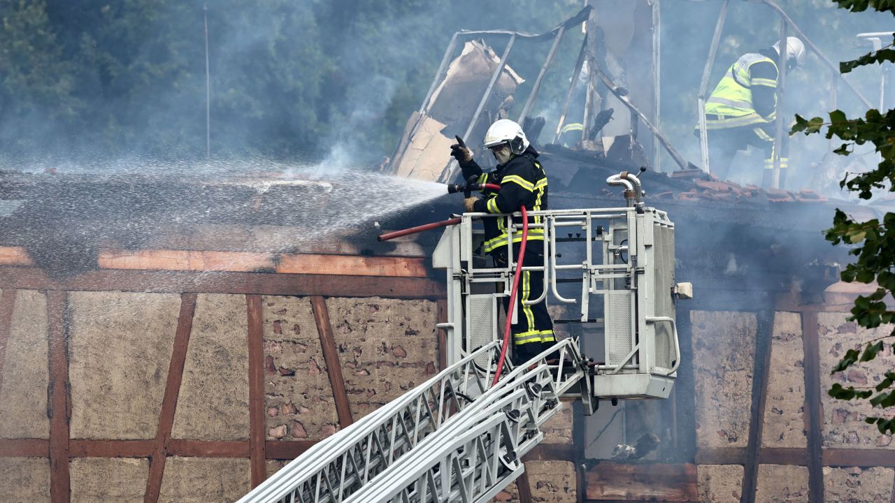 A firefighter sprays water after a fire erupted at a home for disabled people in Wintzenheim near Colmar, eastern France, on August 9, 2023. 