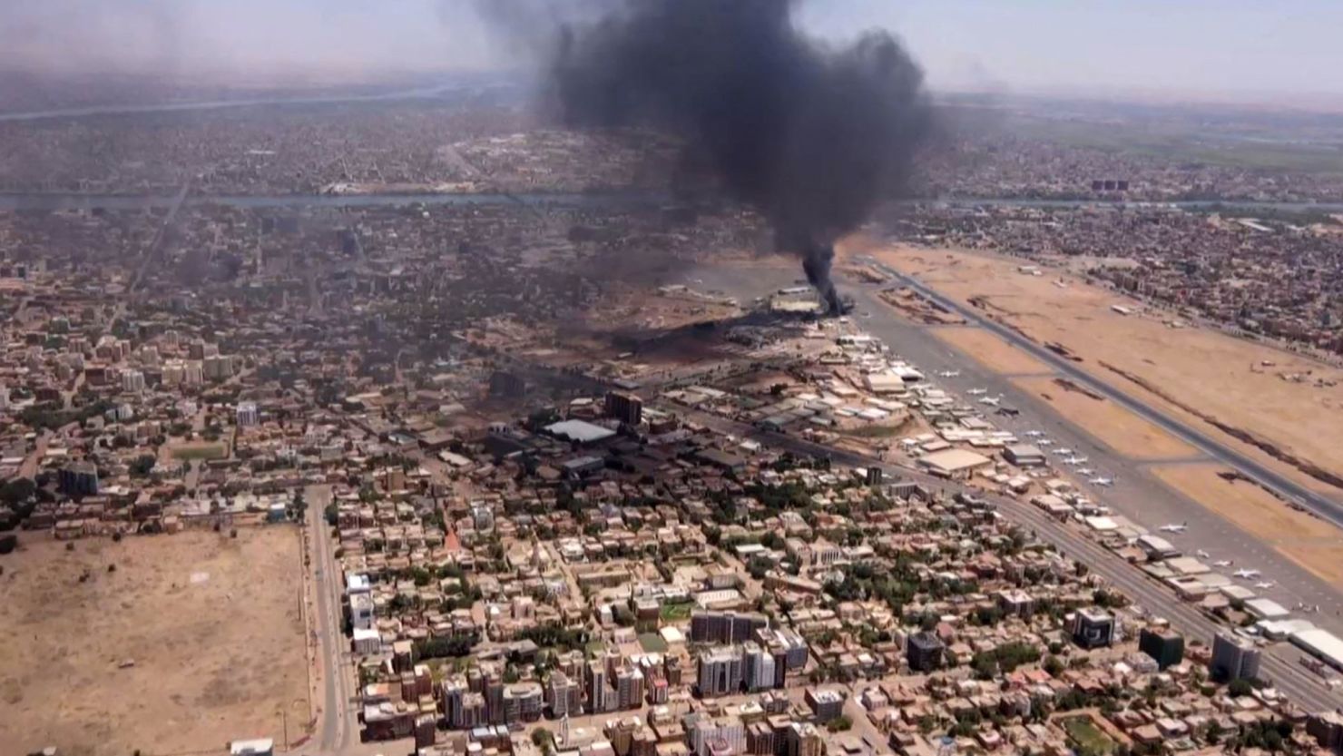 This image grab taken from AFPTV video footage on April 20, 2023, shows an aerial view of black smoke rising above the Khartoum International Airport amid ongoing battles between the forces of two rival generals. - Hundreds of people have been killed since the fighting erupted on April 15 between forces loyal to Sudan's army chief Abdel Fattah al-Burhan and his deputy, Mohamed Hamdan Daglo, who commands the paramilitary Rapid Support Forces (RSF). (Photo by AFP) (Photo by -/AFP via Getty Images)