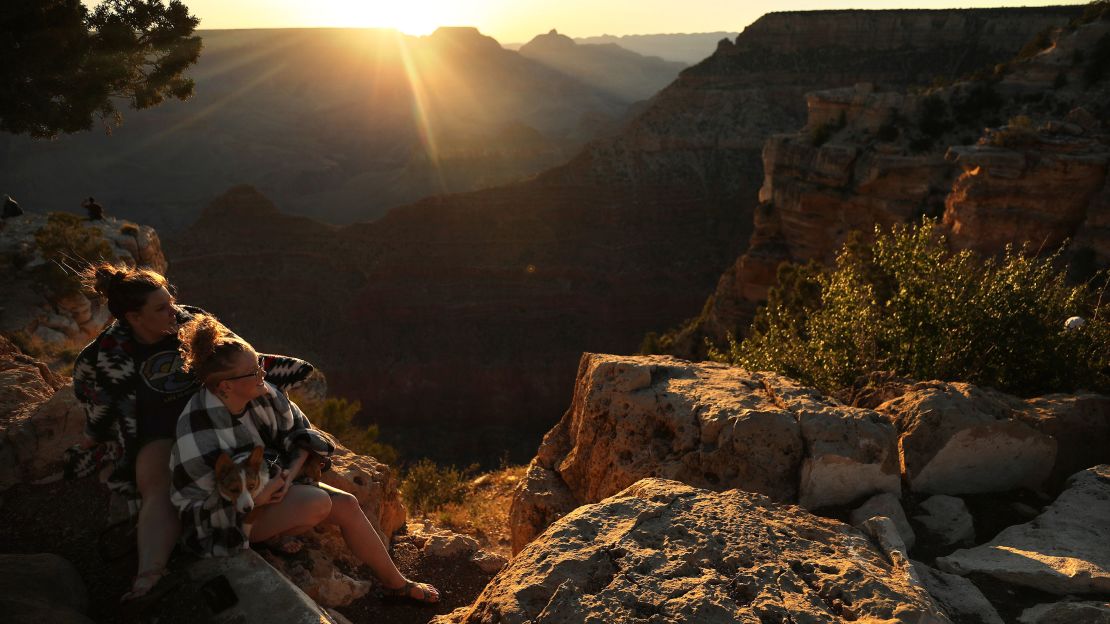 Visitors watch the sun rise along the South Rim of Grand Canyon National Park on May 25, 2020.