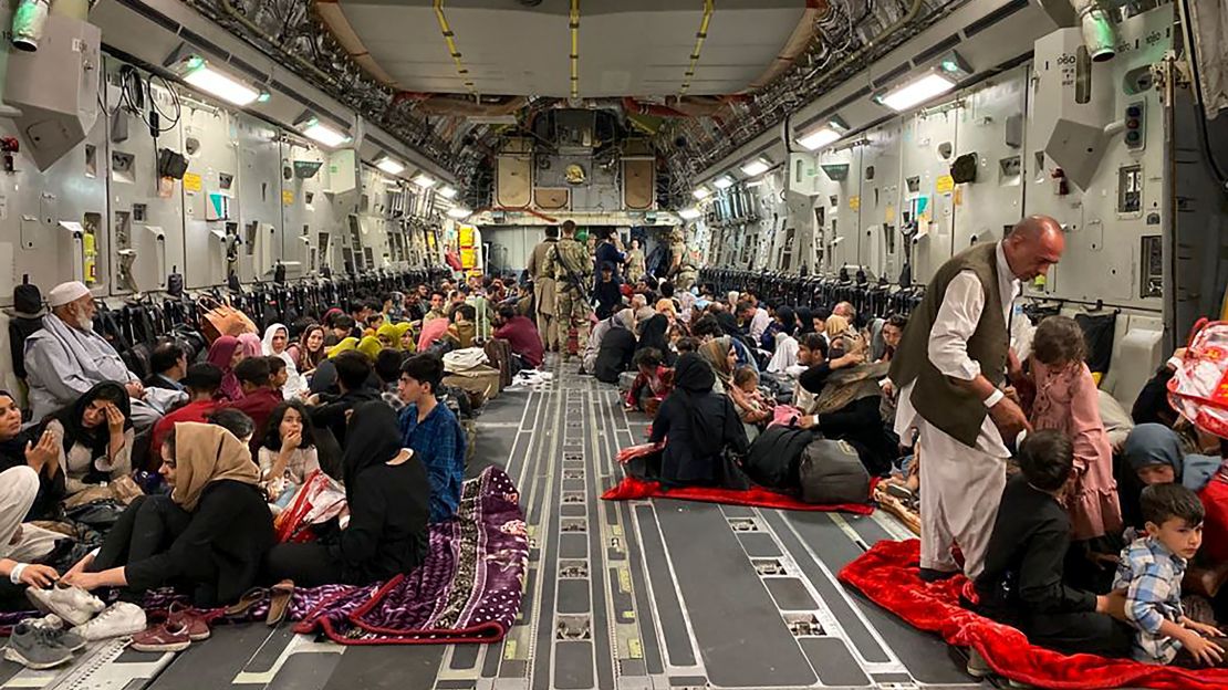 Afghan people sit inside a US military aircraft to leave Afghanistan, at the military airport in Kabul on August 19, 2021 after Taliban's military takeover of Afghanistan.