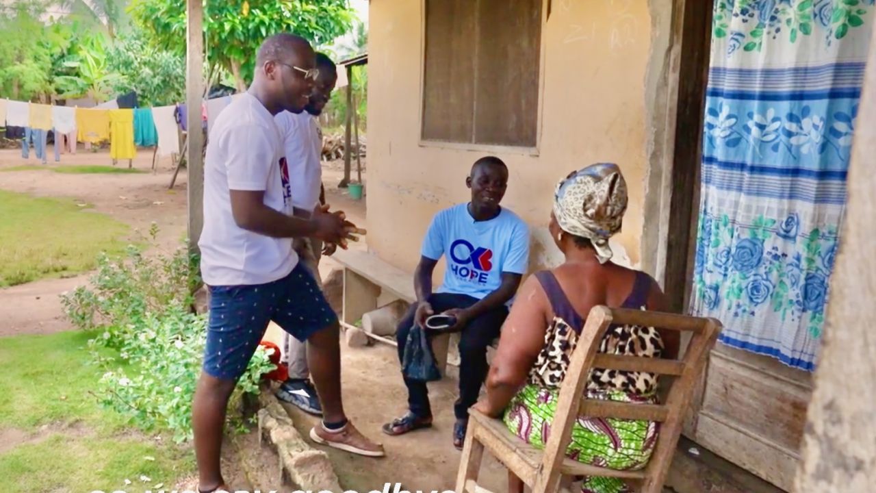 Boateng, left, and two health advocates from his organization check in on a community member.