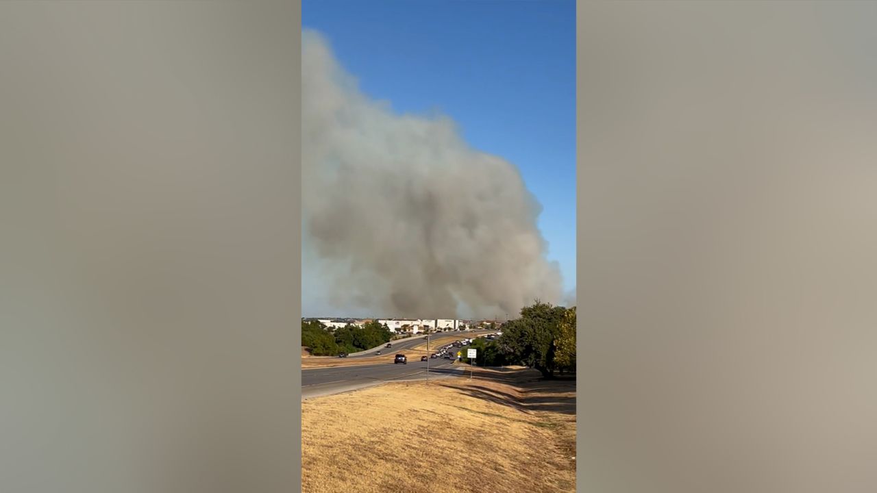 Plumes of smoke hover over an area in Cedar Park, Texas, where a large brush fire was ignited Tuesday.