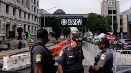 Authorities stand near barricades at the Fulton County courthouse, Monday, Aug. 7, 2023, in Atlanta. 