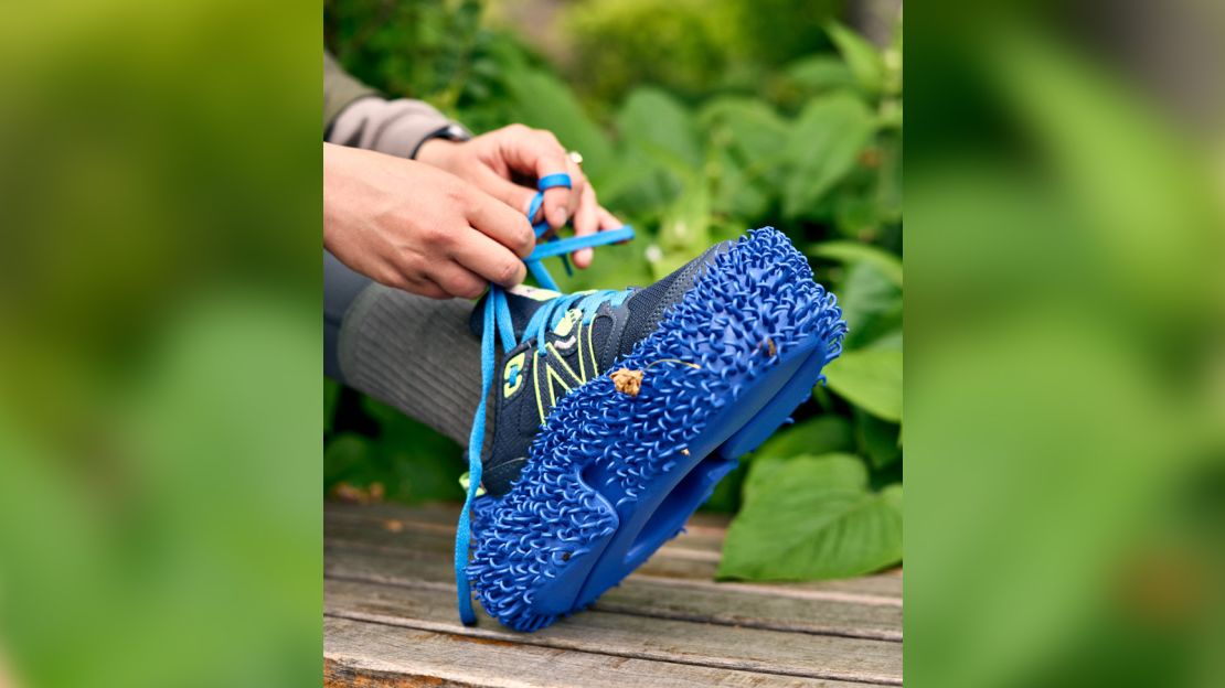 Inspired by nature, the 3D-printed blue outsole, shown here over a running shoe, could help disperse seeds and promote rewilding.