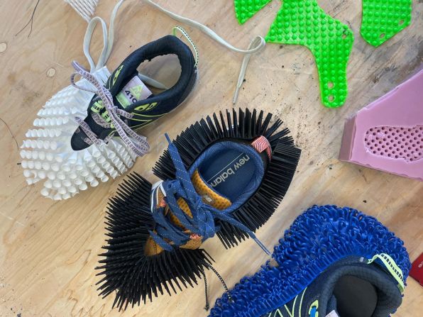 Pictured, a few iterations of the 3D-printed outsole show different designs, leading to the final prototype on the bottom right in blue.