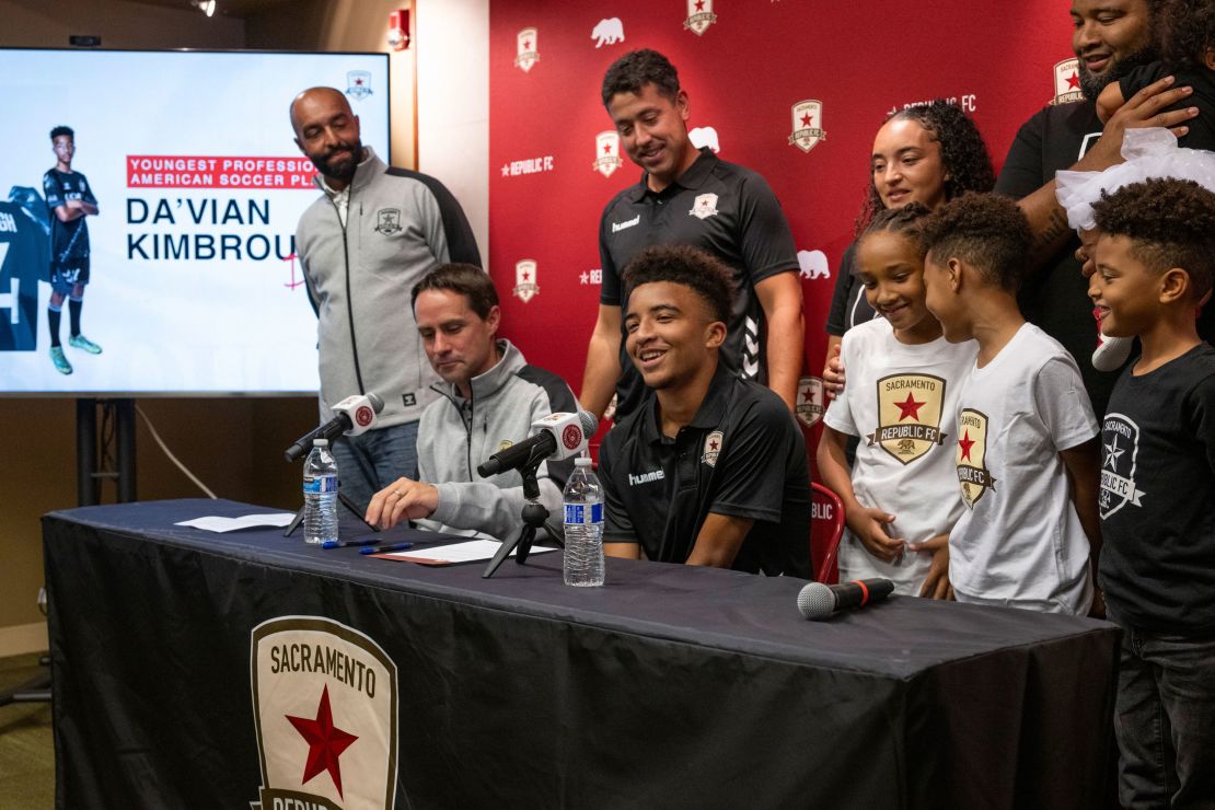 Da'vian Kimbrough, 13, is surrounded by his family and team management after signing contract with the Sacramento Republic of the second-tier League Championship of the United Soccer League, Tuesday, Aug. 8, 2023,  in Sacramento, Calif. (Paul Kitagaki Jr./The Sacramento Bee via AP)