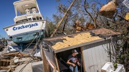 People clear debris in the aftermath of Hurricane Ian in Fort Myers Beach, Florida on September 30, 2022. - Forecasters expect Hurricane Ian to cause life-threatening storm surges in the Carolinas on Friday after unleashing devastation in Florida, where it left a yet unknown number of dead in its wake. After weakening across Florida, Ian regained its Category 1 status in the Atlantic Ocean and was headed toward the Carolinas, the US National Hurricane Center said Friday. (Photo by Giorgio VIERA / AFP) (Photo by GIORGIO VIERA/AFP via Getty Images)