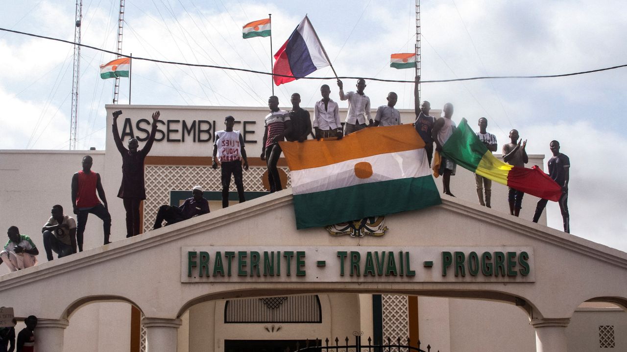 Men hold Niger and Russian flags as they gathers with thousands of anti-sanctions protestors in support of the junta in Niamey, Niger on August 3, 2023. 