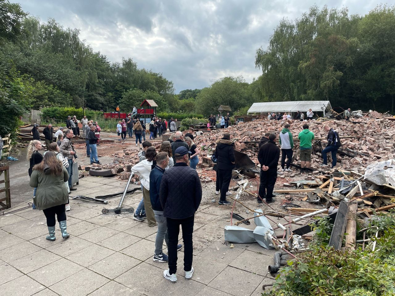People inspect the rubble as they gather at The ruins of The Crooked House pub.
