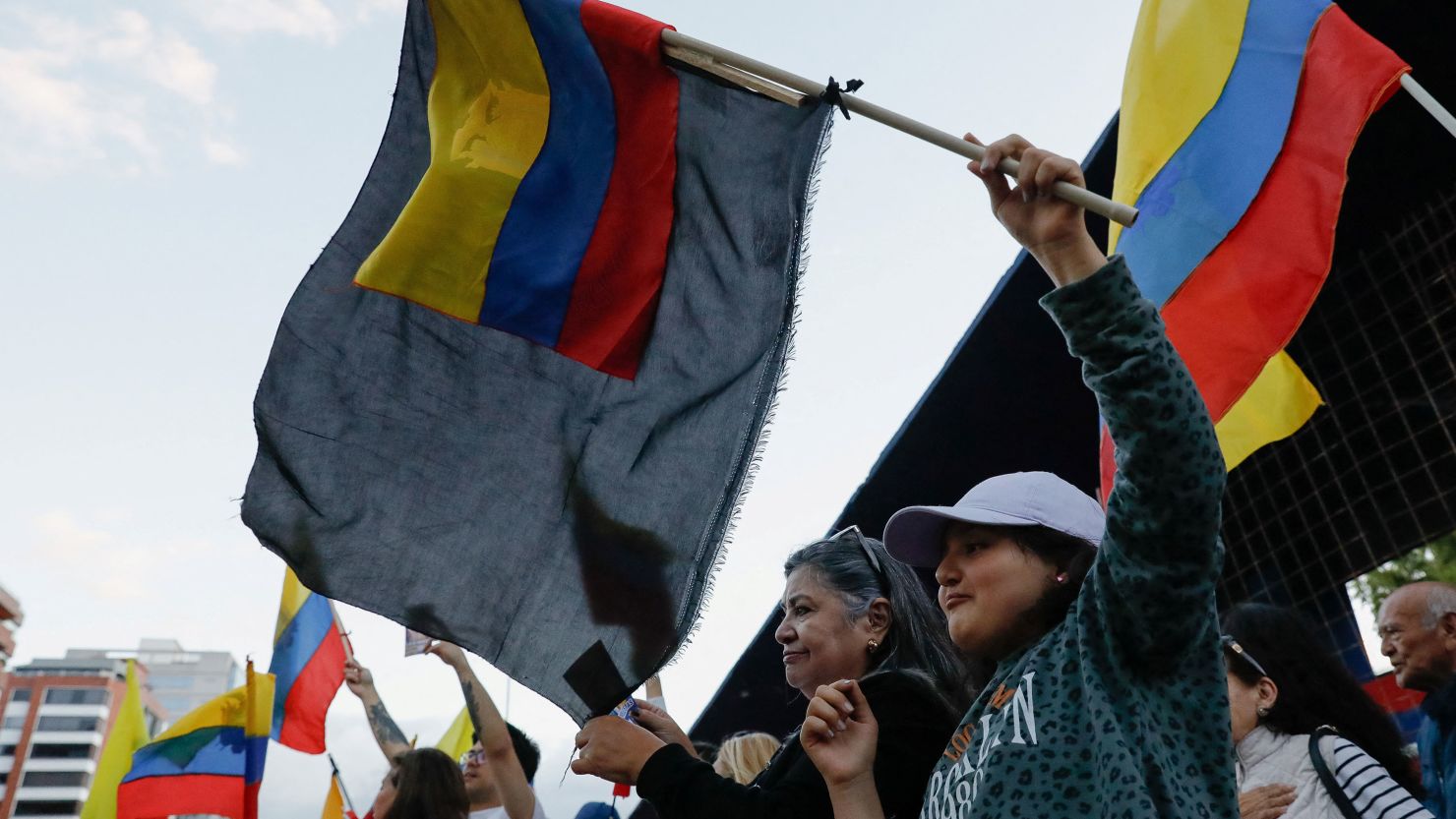 People waving Ecuadorean flags protest after the killing of presidential candidate Fernando Villavicencio.
