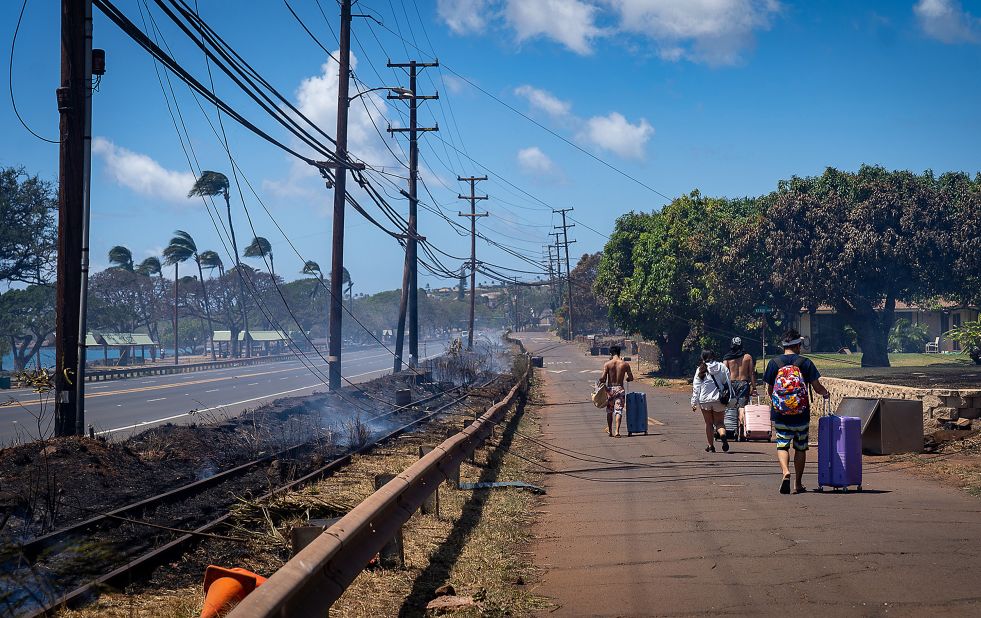 Residents carry their belongings in suitcases after wildfires swept through Lahaina on Wednesday.