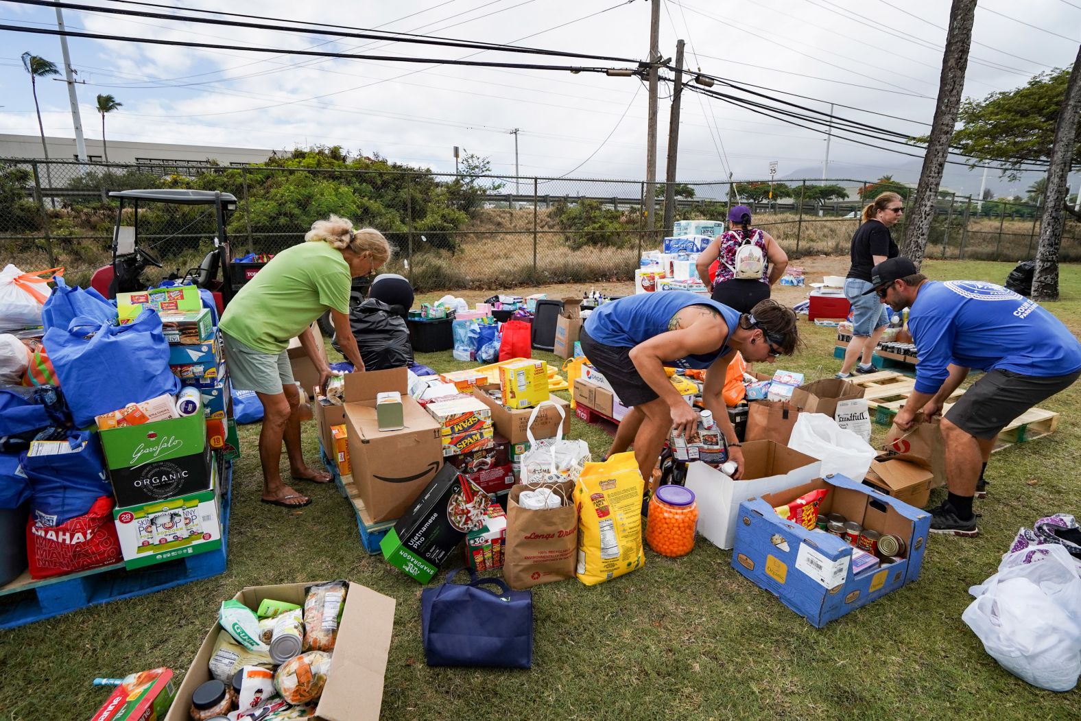 Volunteers stack canned goods at the War Memorial Stadium in Kahului.