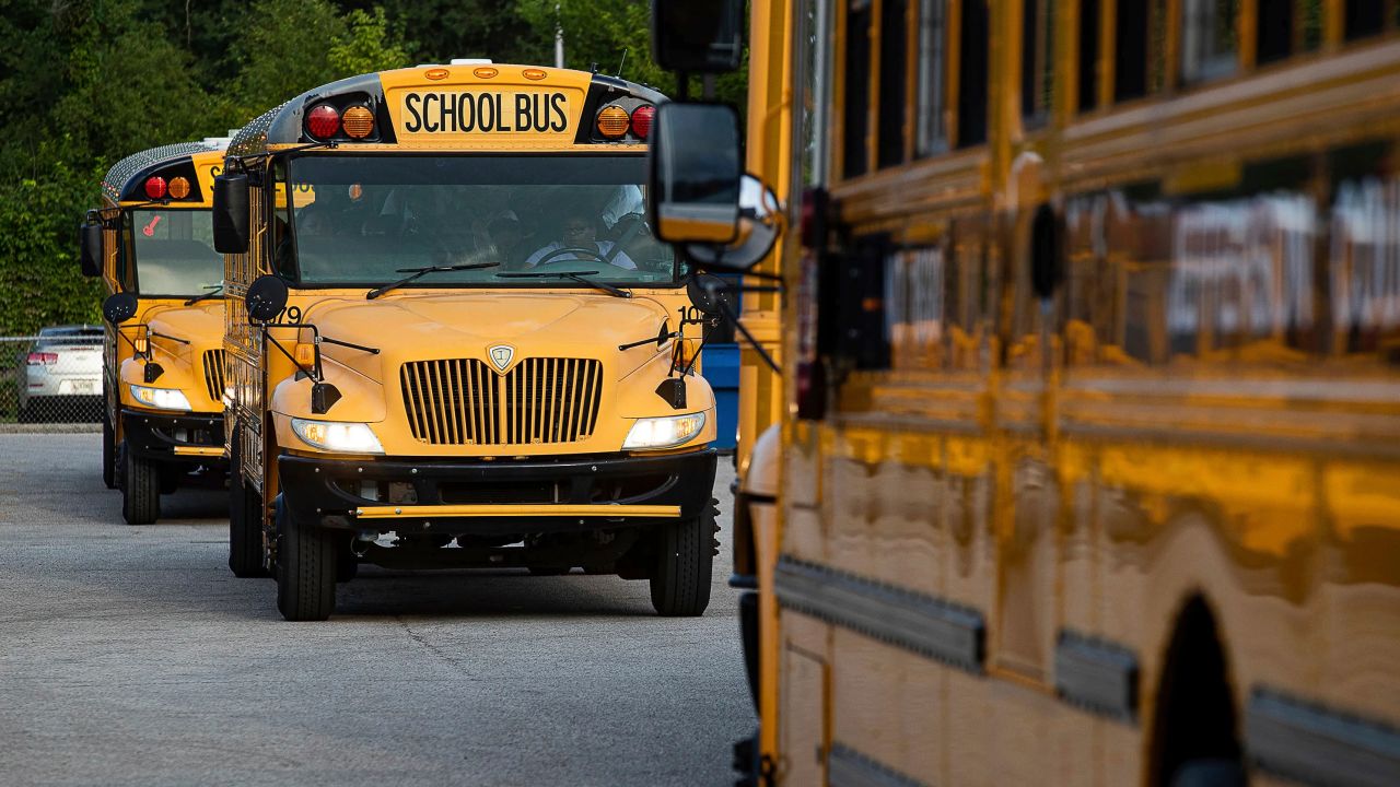Jefferson County Public Schools school buses packed with students makes their way through the Detrick Bus Compound on the first day of school Wednesday, Aug. 9, 2023, in Louisville, Ky. Kentucky's largest school system has cancelled the second and third day of school after a disastrous overhaul of the transportation system that left some children on buses until almost 10 p.m. on opening day. Jefferson County Public Schools Superintendent Marty Pollio calls it a "transportation disaster" in a video posted on social media. (Jeff Faughender/Courier Journal via AP)