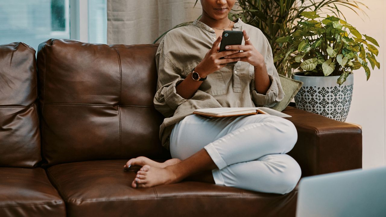 Woman using mobile phone home STOCK