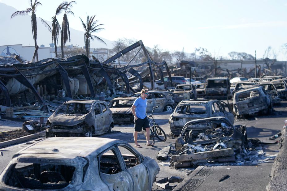 A man walks through damage in Lahaina.