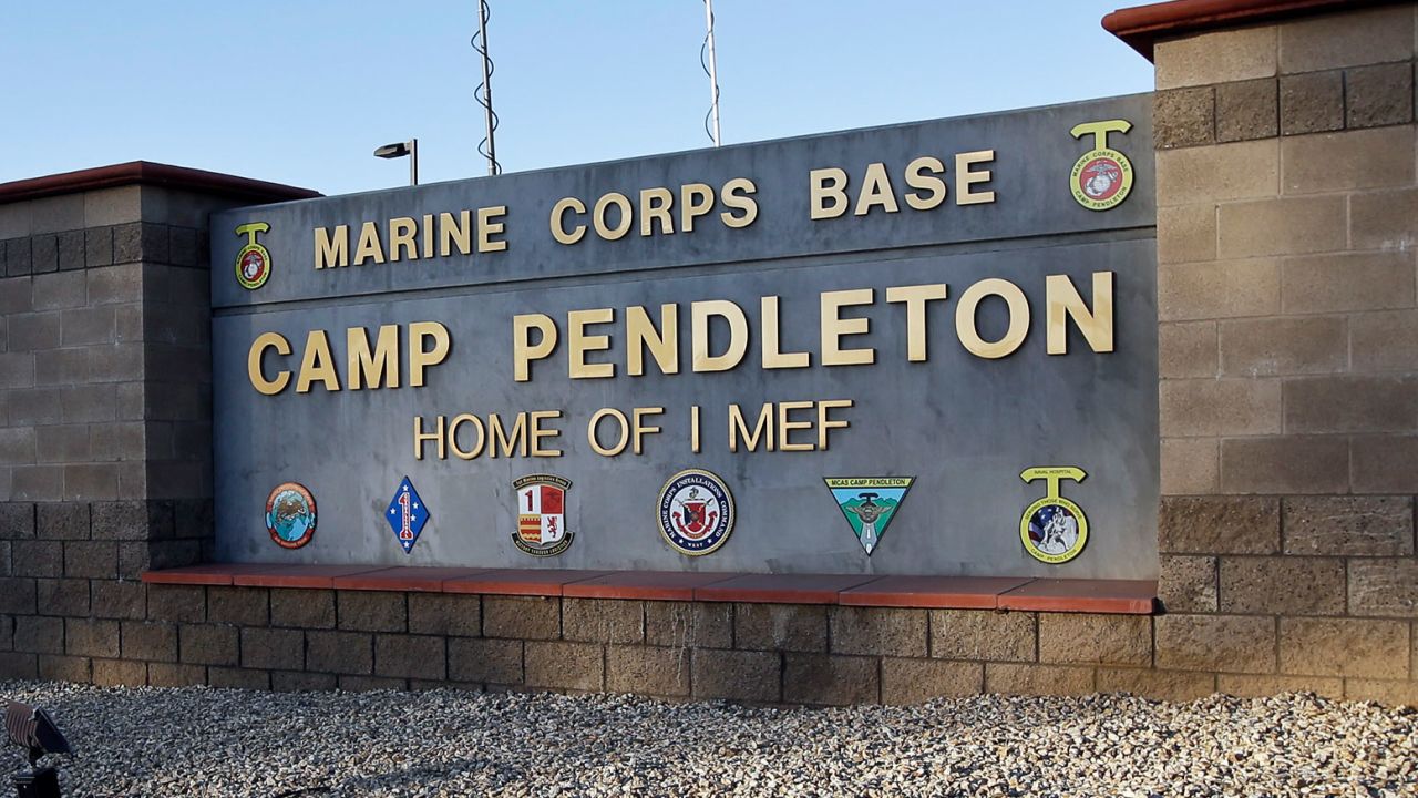 FILE - This Nov. 13, 2013 file photo shows the main gate of Camp Pendleton Marine Base at Camp Pendleton, Calif. A human smuggling investigation by the military led to the arrest of 16 Marines Thursday, July 25, 2019 while carrying out a battalion formation at California's Camp Pendleton, a base about an hour's drive from the U.S.-Mexico border. (AP Photo/Lenny Ignelzi, File)