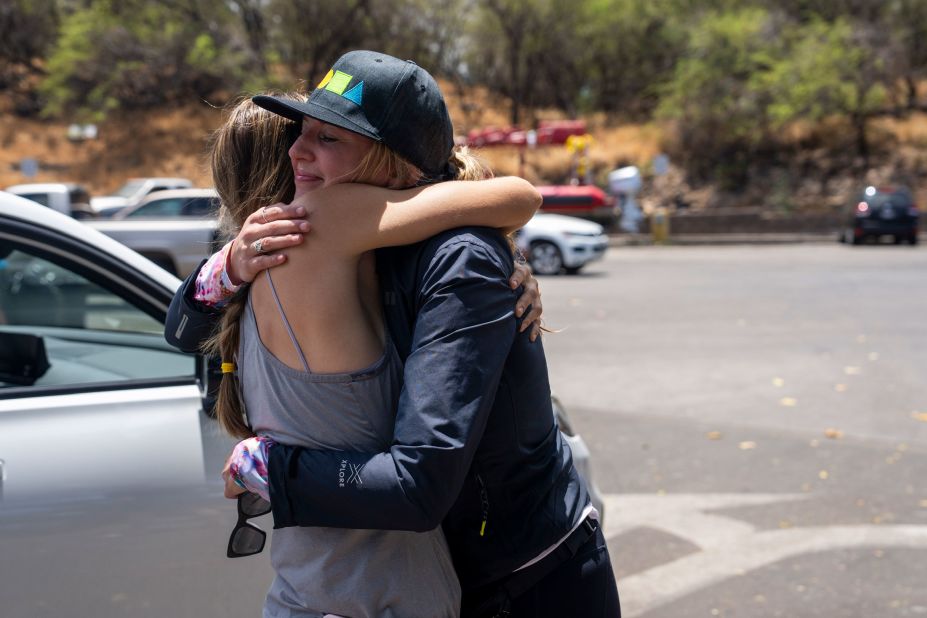 Grace Hurt, right, embraces someone while loading supplies for those in need at Kihei Ramp in Maui, Hawaii, on Saturday. "The reason why we are out here today is because we have ohana on the west side, boots on the ground that have no roof over their heads," Hurt said. "We are in an effort with the entire community here, we are trying to get them supplies directly."