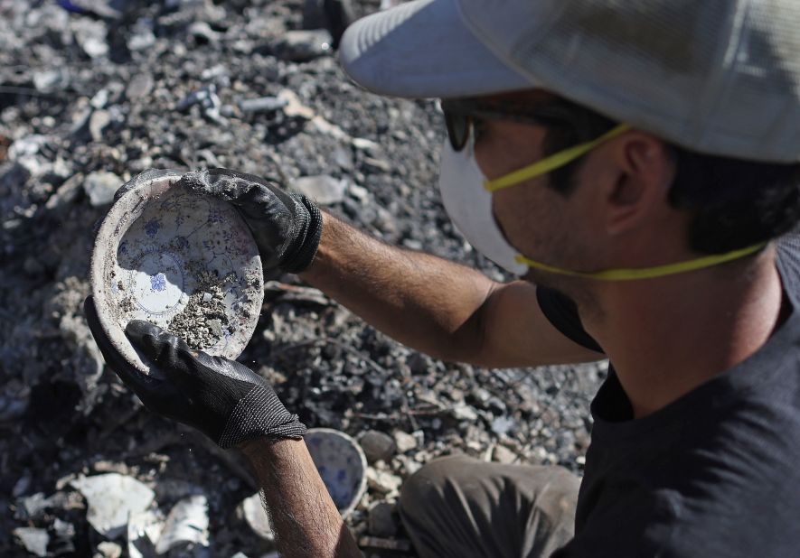 Brook Cretton salvages a bowl he found while sifting through the rubble of a home in Kula.