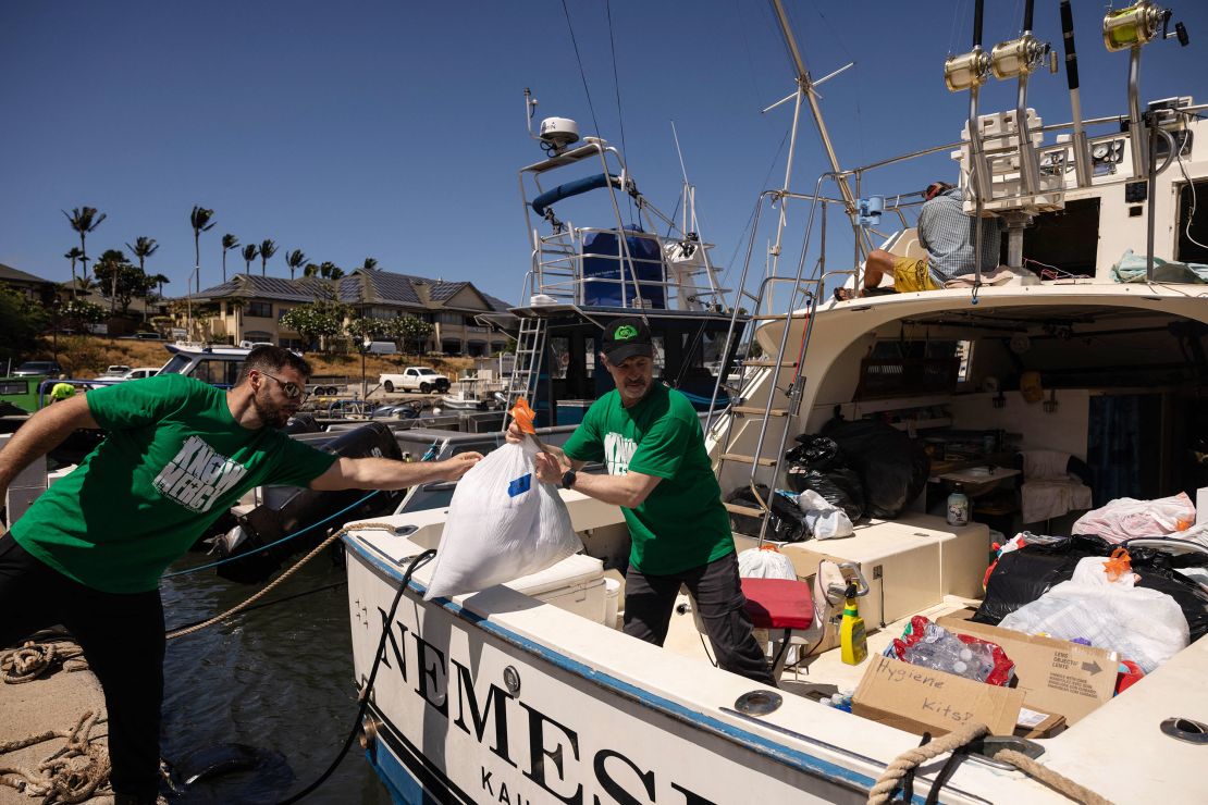 Volunteers in Maalaea, Hawaii, on August 12, 2023, load a boat with supplies to deliver to West Maui towns affected by wildfires. 