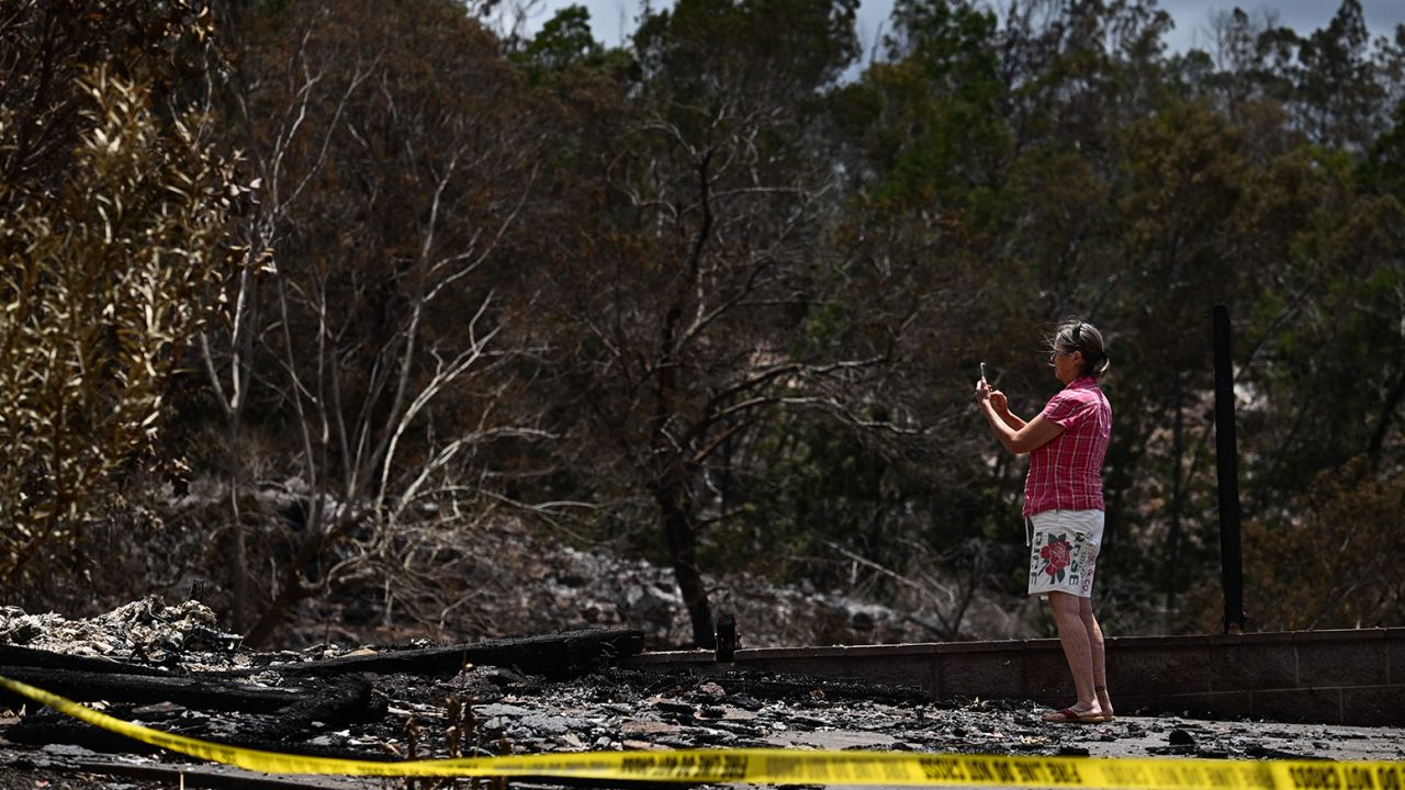Un cuidador fotografía el sitio de una casa destruida por los incendios forestales de Maui en Kula, Hawái el domingo.