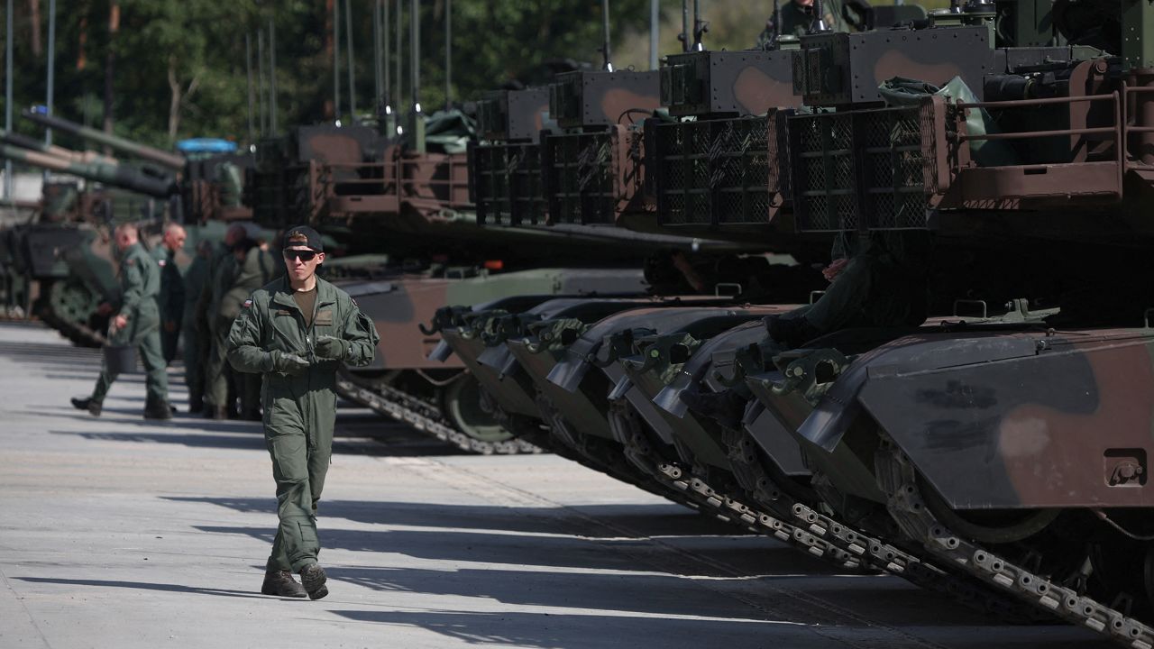 Polish soldiers walk near Abrams M1A1 tanks during preparations for Tuesday's parade.