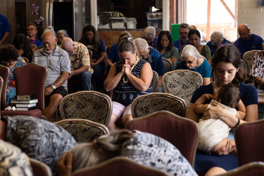 People pray during a church service in Wailuku on August 13. The Maui Coffee Attic opened up space for the service after a wildfire destroyed Lahaina's Grace Baptist Church.