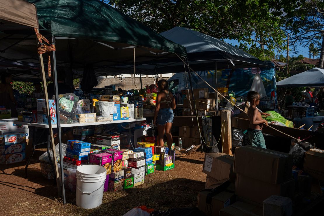 Supplies are sorted, stored and sent out from under a blue tarp.