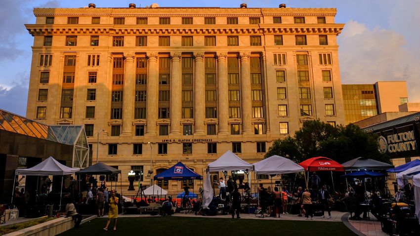 Media vehicles stage outside the Fulton County Courthouse, Monday, Aug. 14, 2023, in Atlanta.