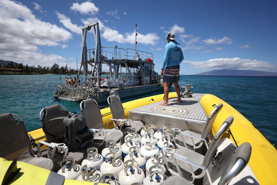 A volunteer prepares to dock next to a fishing boat to transfer propane tanks that would be ferried to shore in Kaanapali, Hawaii, on August 14.