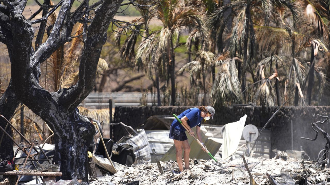 Una mujer excava entre los escombros de una casa destruida por un incendio forestal el viernes 11 de agosto de 2023 en Lahaina, Hawái. 