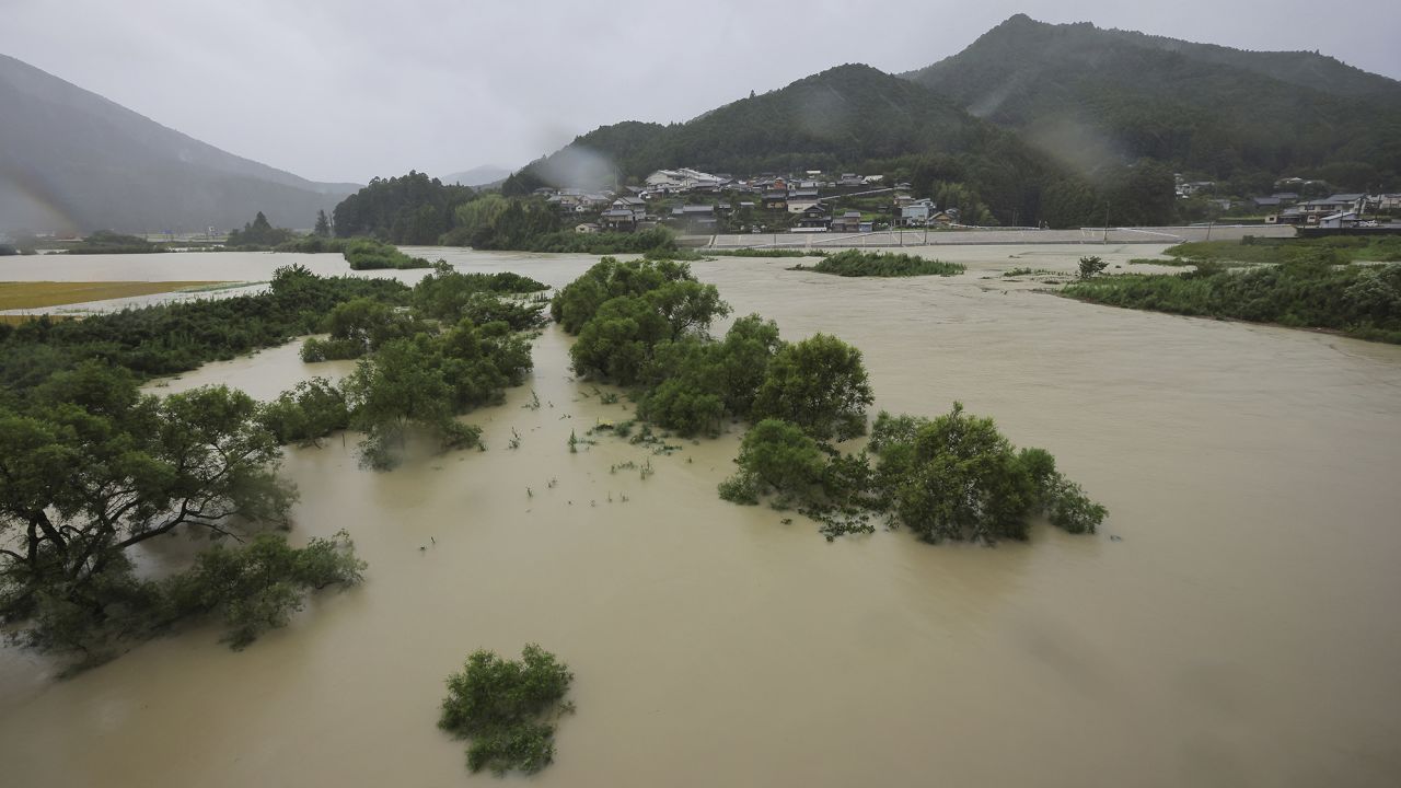  Придошла река, тъй като тайфунът Лан достига сушата до град Шингу, префектура Уакаяма във вторник. class=