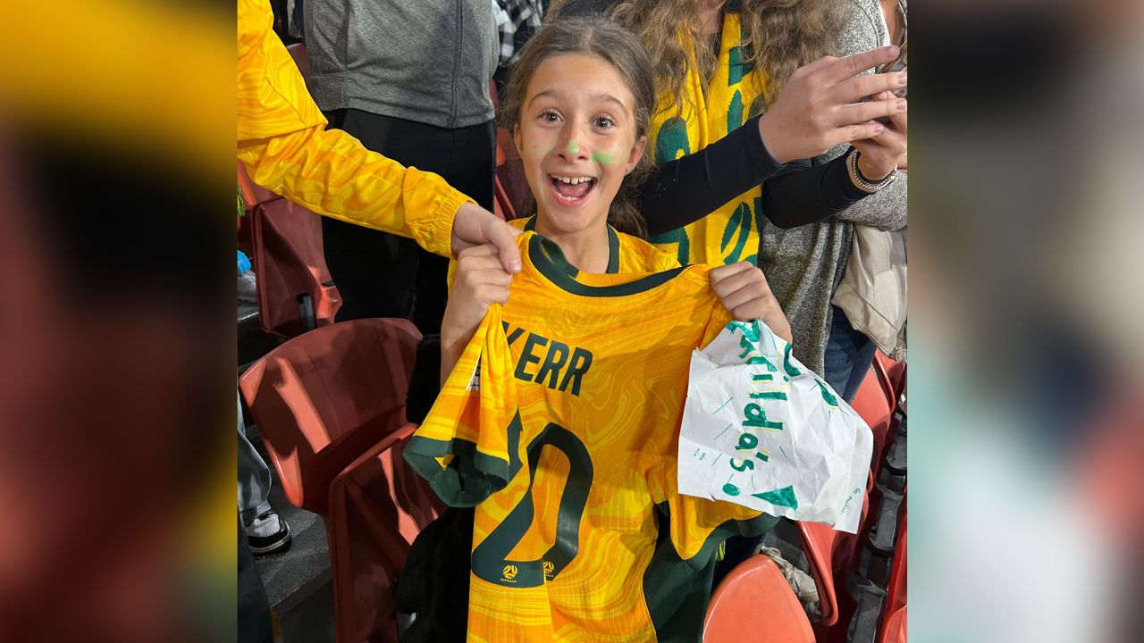 Zara Borcak beams as she holds the jersey Sam Kerr gave her after Saturday's match against France, August 12, 2023.